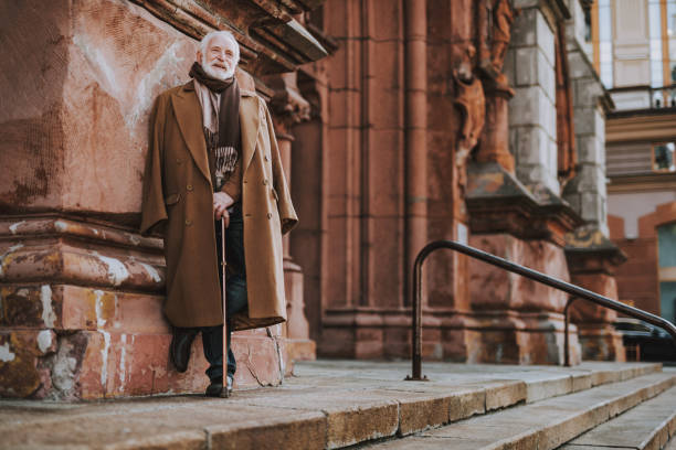 istock Senior gentleman with walking stick posing near old building 1096001834