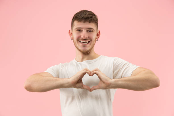 istock Attractive guy is making a heart shape symbol with his fingers. 1096012174