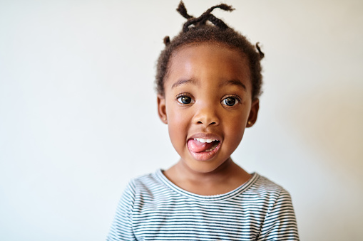 Portrait of an adorable little girl playfully sticking out her tongue
