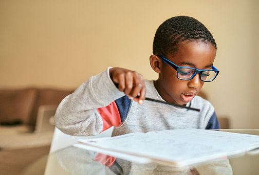 Shot of an adorable little boy doing his schoolwork at home