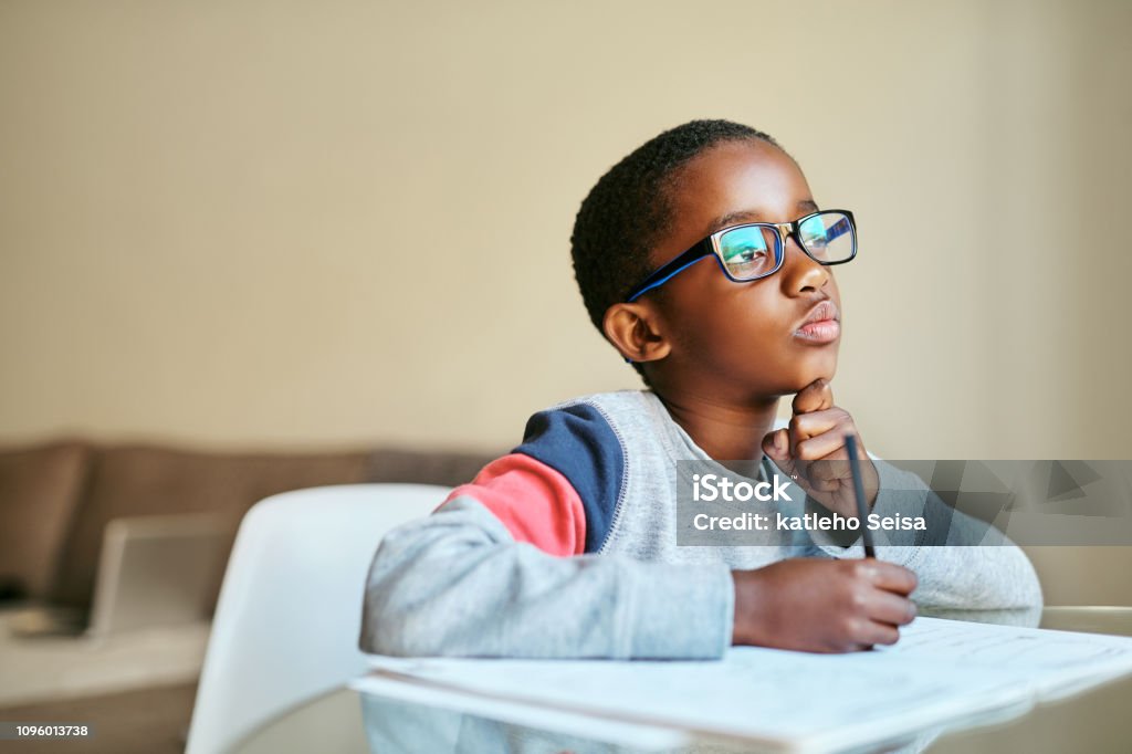 Open your mind to knowledge Shot of an adorable little boy doing his schoolwork at home Child Stock Photo