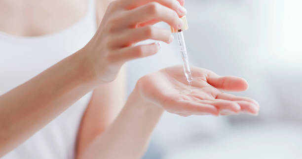 woman dropping moisturizer in hand