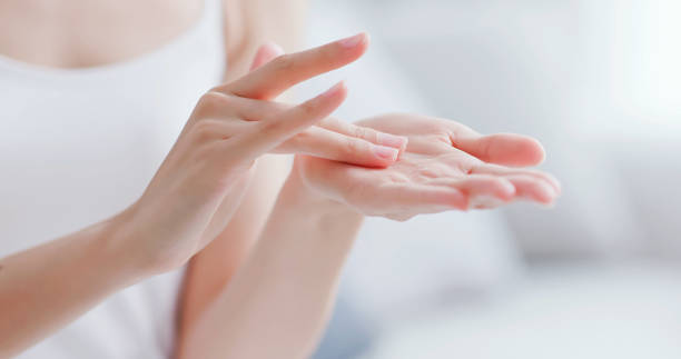 woman apply moisturizer in hand stock photo