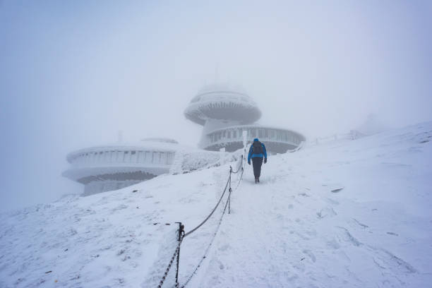 Climbing to the top in the mist in the snow