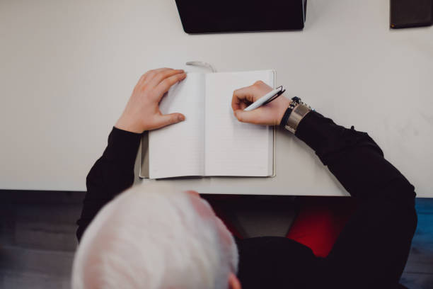 istock Older man at  the office desk writing in his notebook 1096017466