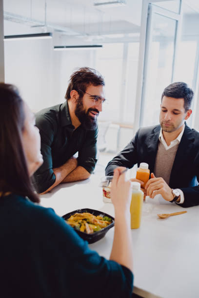 istock Man smiling in the office cafeteria while colleagues eating 1096017534