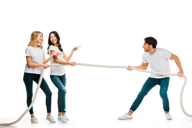 istock smiling young women and concentrated man pulling rope isolated on white 1096019146