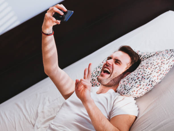 istock Young man taking a selfie in the bed 1096028192