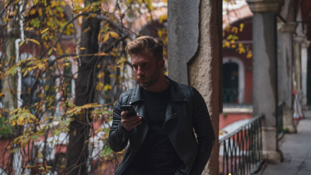 istock Blond boy playing with the phone under the leaves 1096029358
