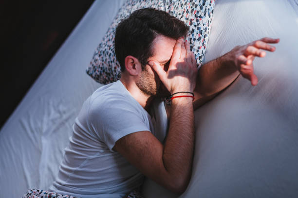 istock Young tired man waking up in bed in the morning 1096033616