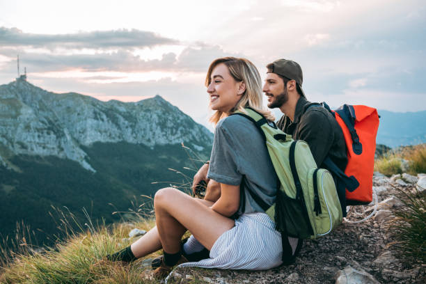 ハイキング、休憩を取って後リラックスした美しい若いカップル - 観光客 写真 ストックフォトと画像