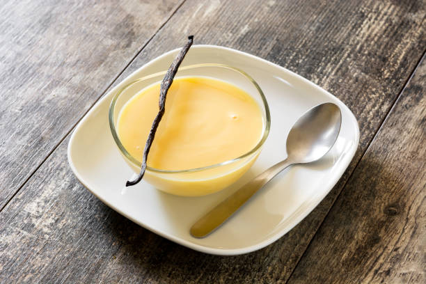 Vanilla custard Bowl of homemade vanilla custard on wooden table custard stock pictures, royalty-free photos & images