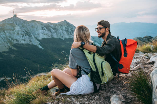 istock beautiful young couple relaxing after hiking and taking a break 1096035518