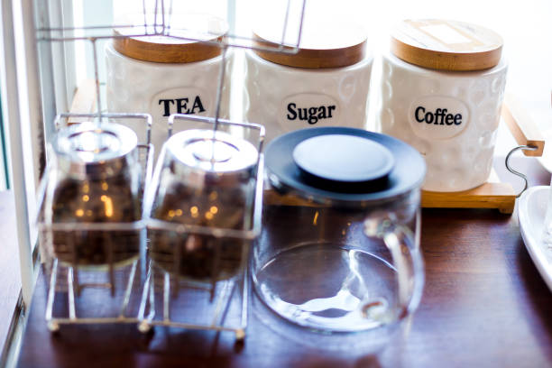 coffee bean and tea with sugar in a glass jar on wooden table in cafe