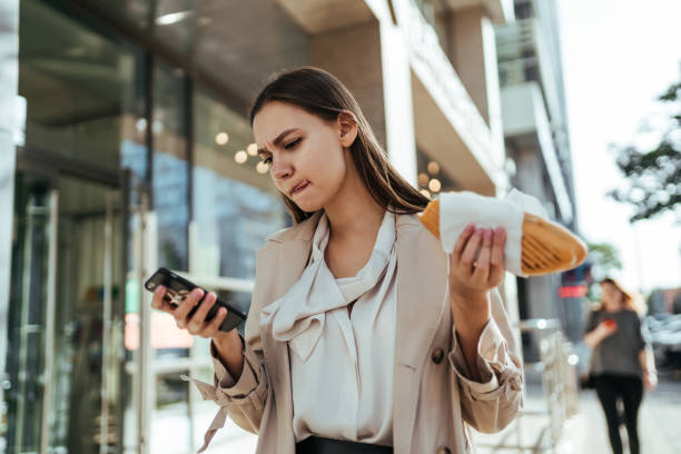 the busy businesswoman working online on a smartphone during a break - lanche da tarde imagens e fotografias de stock
