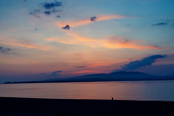 istock A lone figure in the sunset on the beach. 1096045792
