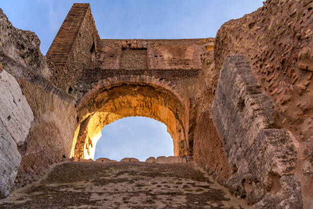 Stone Arch - Evening sunlight shining on a stone arch at top of ancient high wall of the Colosseum. Rome, Italy. stock photo