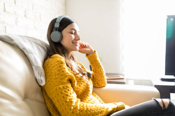 mujer disfrutando de la música en auriculares inalámbricos - chill out audio fotografías e imágenes de stock
