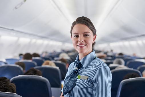 Portrait of a confident young air hostess working on an airplane