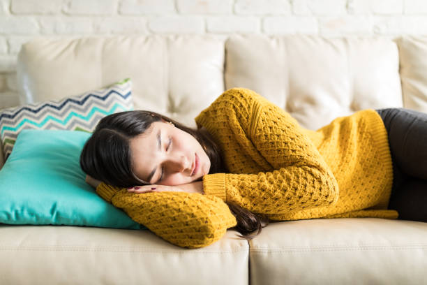 Woman Sleeping Comfortably In Living Room Beautiful woman taking break for short sleep in middle of day at home napping photos stock pictures, royalty-free photos & images