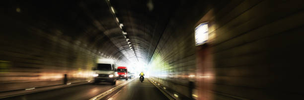 dangerous oncoming traffic inside a road tunnel - two way traffic imagens e fotografias de stock