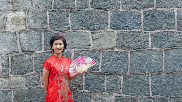 solo-weibliche touristen in chinesische traditionelle kleidung mit steinmauer - thailand asia famous place stone stock-fotos und bilder