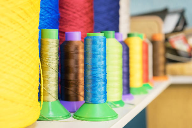istock Closeup of coils with colored threads on the shelf in sewing workshop 1096077592
