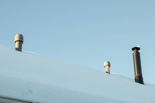 istock Three chimneys on the snow-covered roof 1096079008