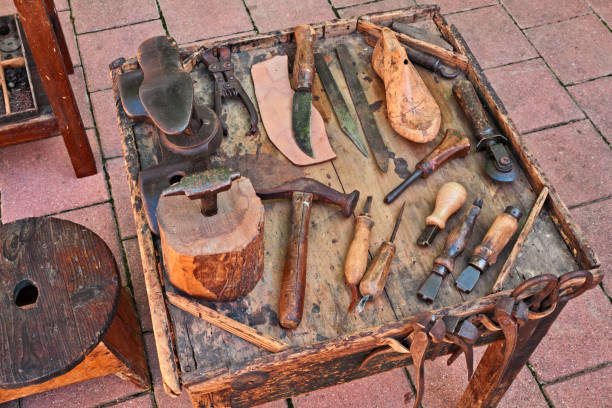 old tools of the shoemaker work table with old tools of the artisan shoemaker to cut and shape the leather to make shoes shoe mold stock pictures, royalty-free photos & images