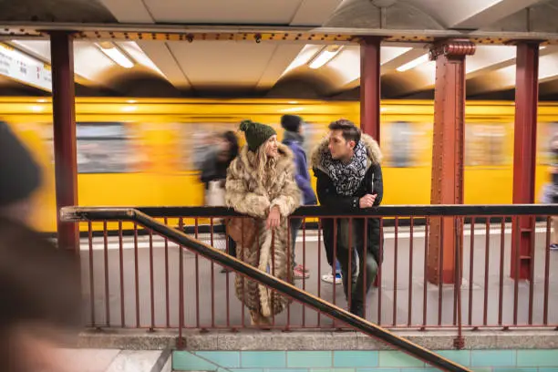 Photo of Young couple waiting for their train and chatting