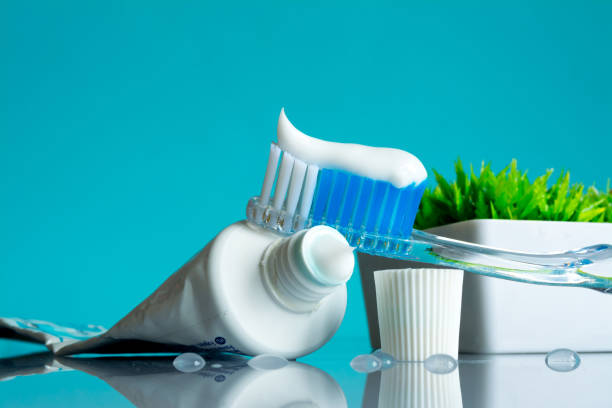 istock New toothbrush with toothpaste close-up in the bathroom on a mirror table with water drops on a blue background in the sunlight 1096112266