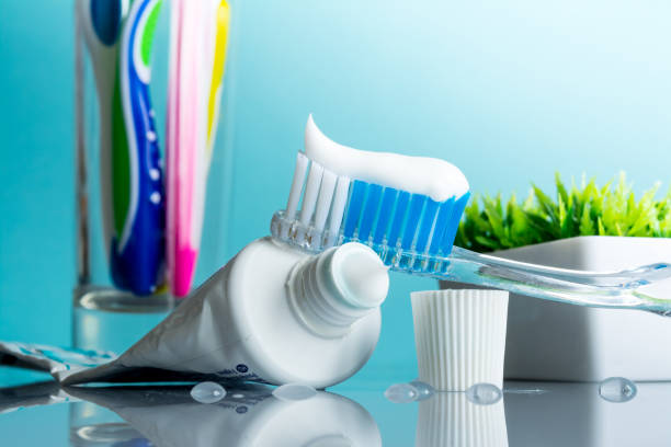 istock New toothbrush with toothpaste close-up in the bathroom on a mirror table with water drops on a blue background in the sunlight 1096112382