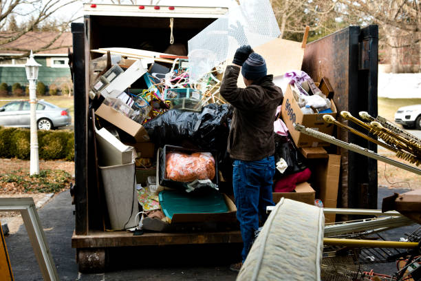 Workman loading dumpster in driveway House cleanout, disposing of household items.
Image shot with Canon 5D Mark 4, 24-105mm f/4L IS USM lens. Junk removal stock pictures, royalty-free photos & images