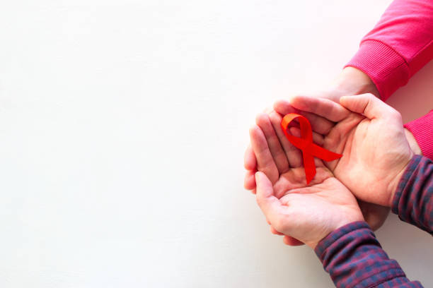 man and woman hold red ribbon