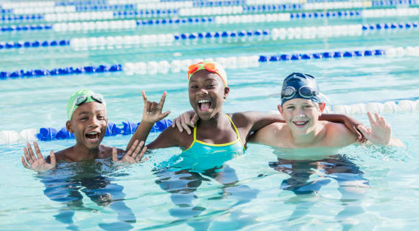 Multi-ethnic children in swimming pool smiling at camera