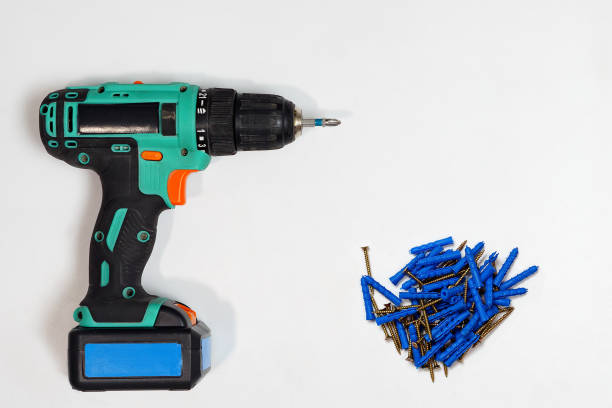 istock arranged drill with pile of nails on white background 1096127216