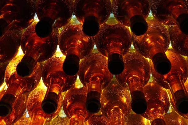 file di bottiglie di vino retroilluminate in cantina - wine wine rack winery black foto e immagini stock