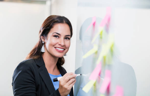 istock Hispanic businesswoman giving presentation at whiteboard 1096132696