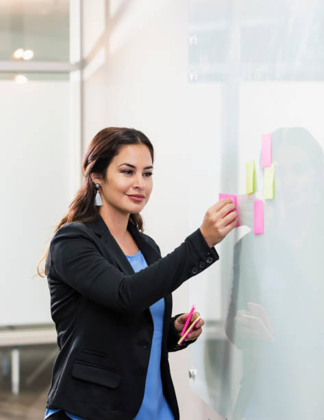 istock Hispanic businesswoman giving presentation at whiteboard 1096133128