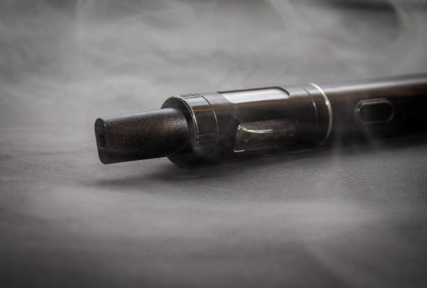 istock electronic cigarette in light smoke haze, vaporizer close on isolated on dark background 1096136410