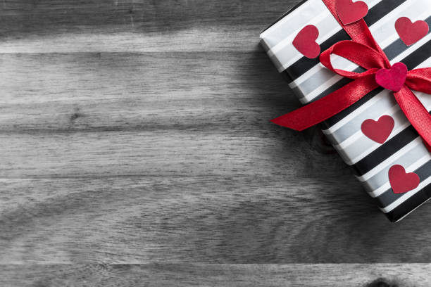Black and white photo with a focus on red color as a symbol of love. Valentine's day greeting card with place for text.