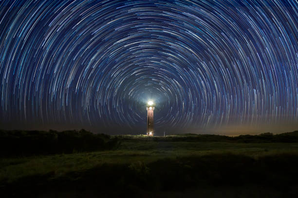 istock Lighthouse at night with star trails at the center 1096153868