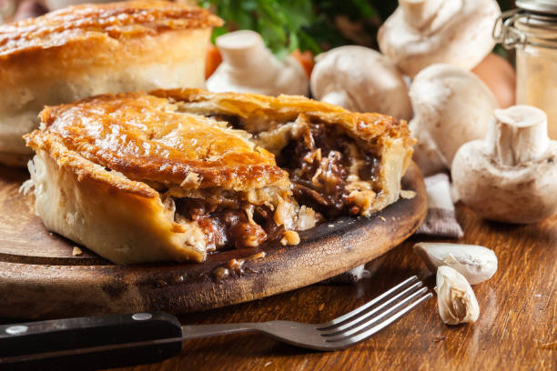 Fresh beef stew pie on a cutting board Fresh beef stew pie on a cutting board. Meat in puff pastry savory food photos stock pictures, royalty-free photos & images