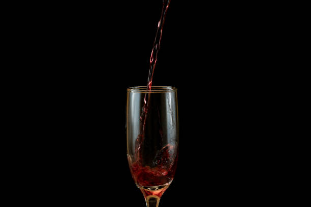 Photograph of juice in a glass jar with water waves. There are bubbles and the background is white.