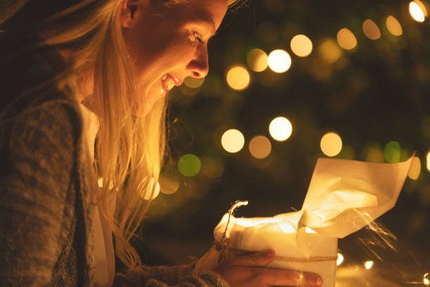 istock Woman opening a gift box with a gift inside. She is smiling. 1096175406