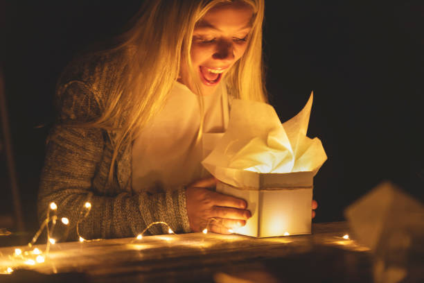 istock Woman opening a gift box with a gift inside. Her mouth is open in surprise. 1096175408