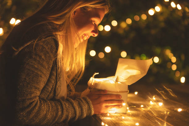 istock Woman opening a gift box with a gift inside. She is smiling. 1096175414