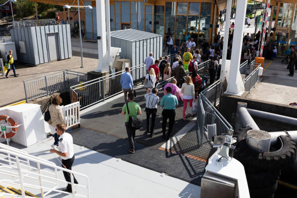 Passengers are unloading off the ferry moored in the Oslofjord on a sunny summer day. The Oslofjord is an inlet in the south-east of Norway, stretching from an imaginary line between the Torbjornskjaer and Faerder lighthouses and down to Langesund in the south to Oslo in the north.