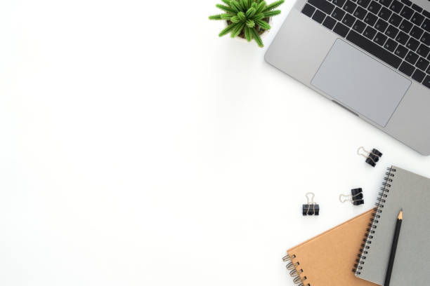 istock Creative flat lay photo of workspace desk. Top view office desk with laptop, pencil, notebook and plant on white color background. Top view with copy space, flat lay photography. 1096222452
