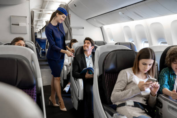 Flight attendant checking on a man in the airplane Portrait of a happy flight attendant checking on a man in the airplane air stewardess stock pictures, royalty-free photos & images